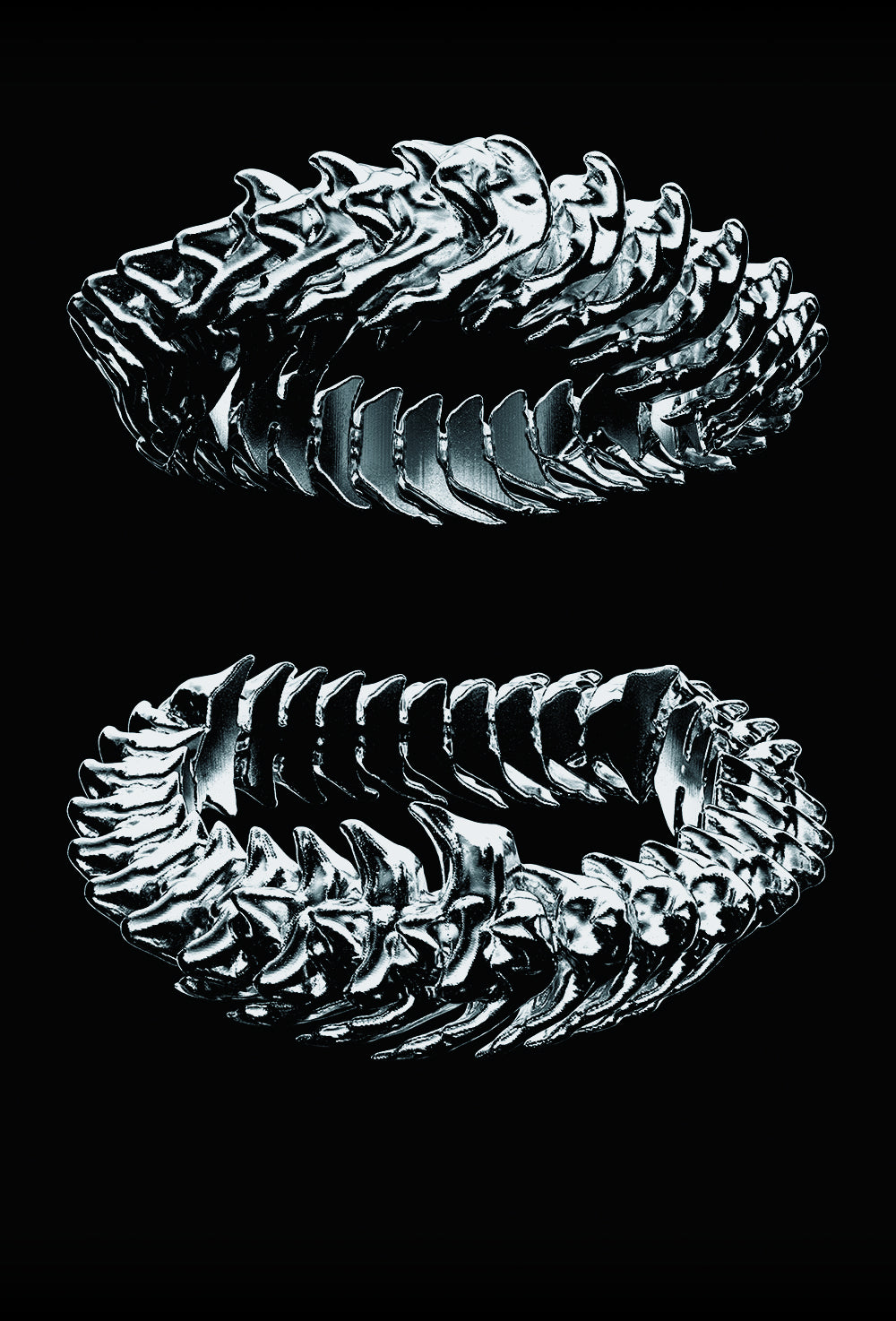 Two silver rings with intricate designs on a black background