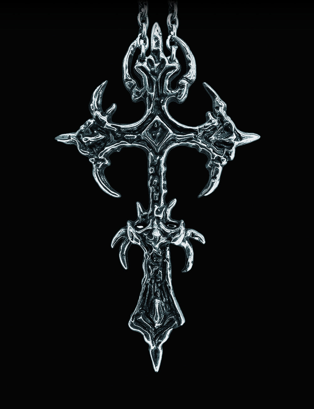 Decorative silver cross pendant on a black background