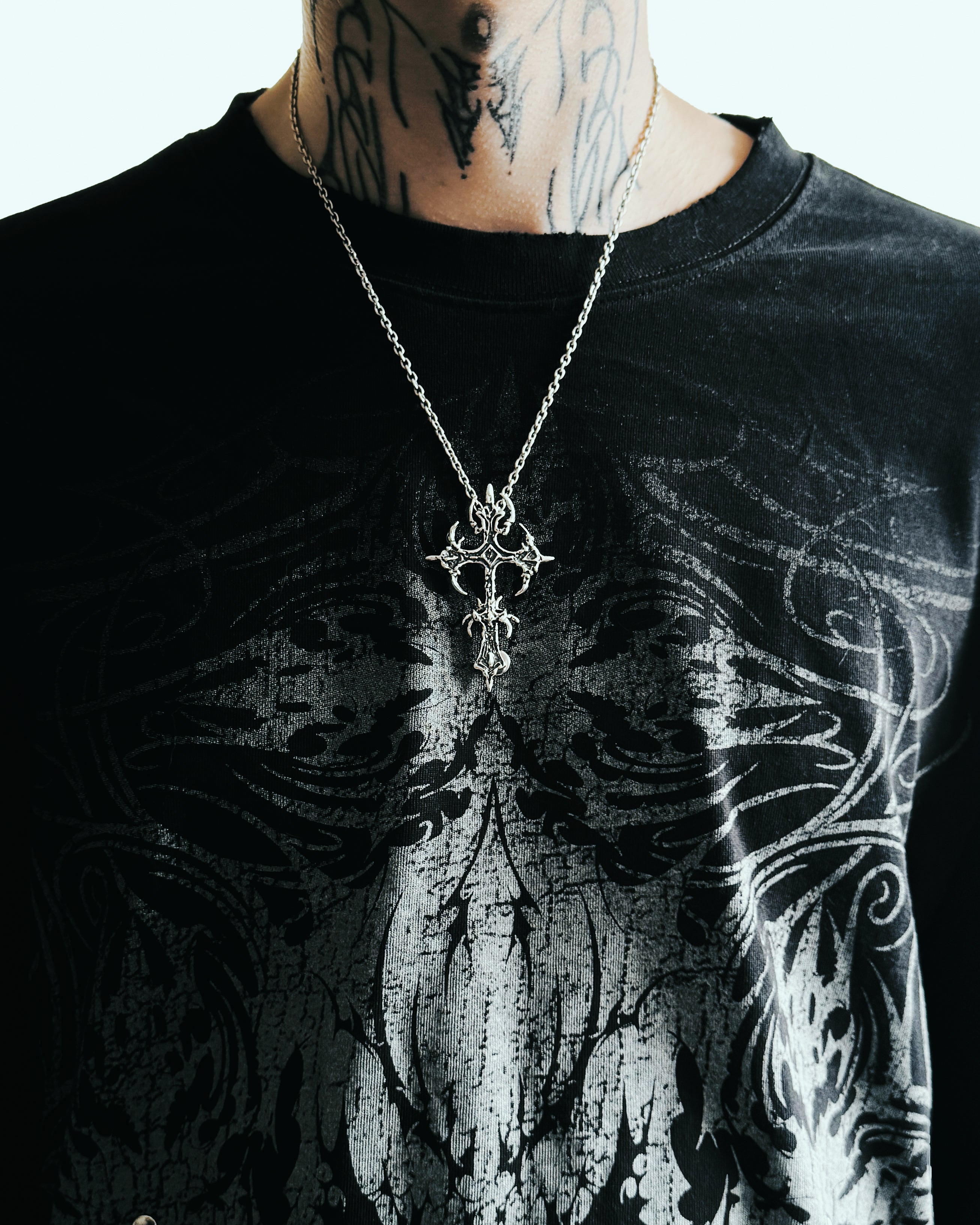 Sterling silver cross on male body, studio shot
