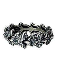 A silver ring with a textured design resembling interlocking bones or vertebrae, displaying craftsmanship with a dark background.