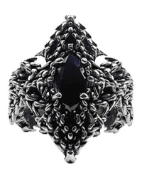 A stainless steel ring with a trident-shaped design, featuring a central black gemstone and intricate textures around the band.
