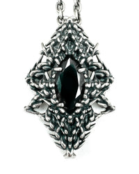 A silver necklace featuring a claw-set black gemstone with intricate designs on the sides.